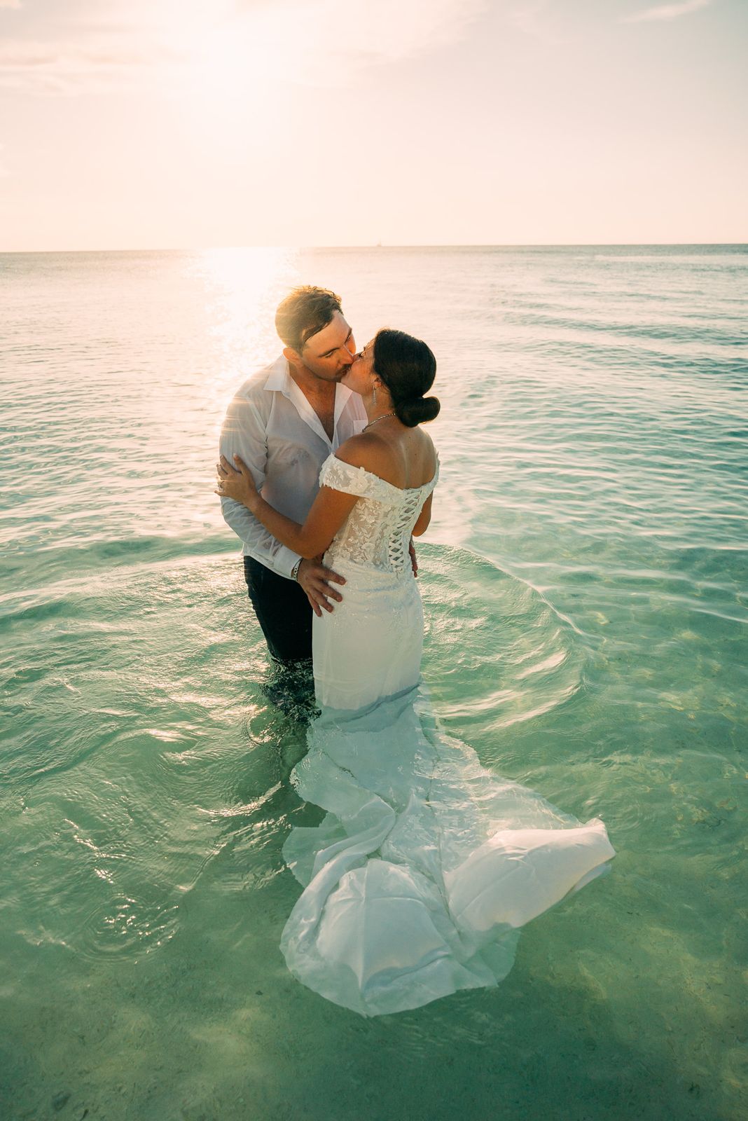 Couple in ocean after wedding