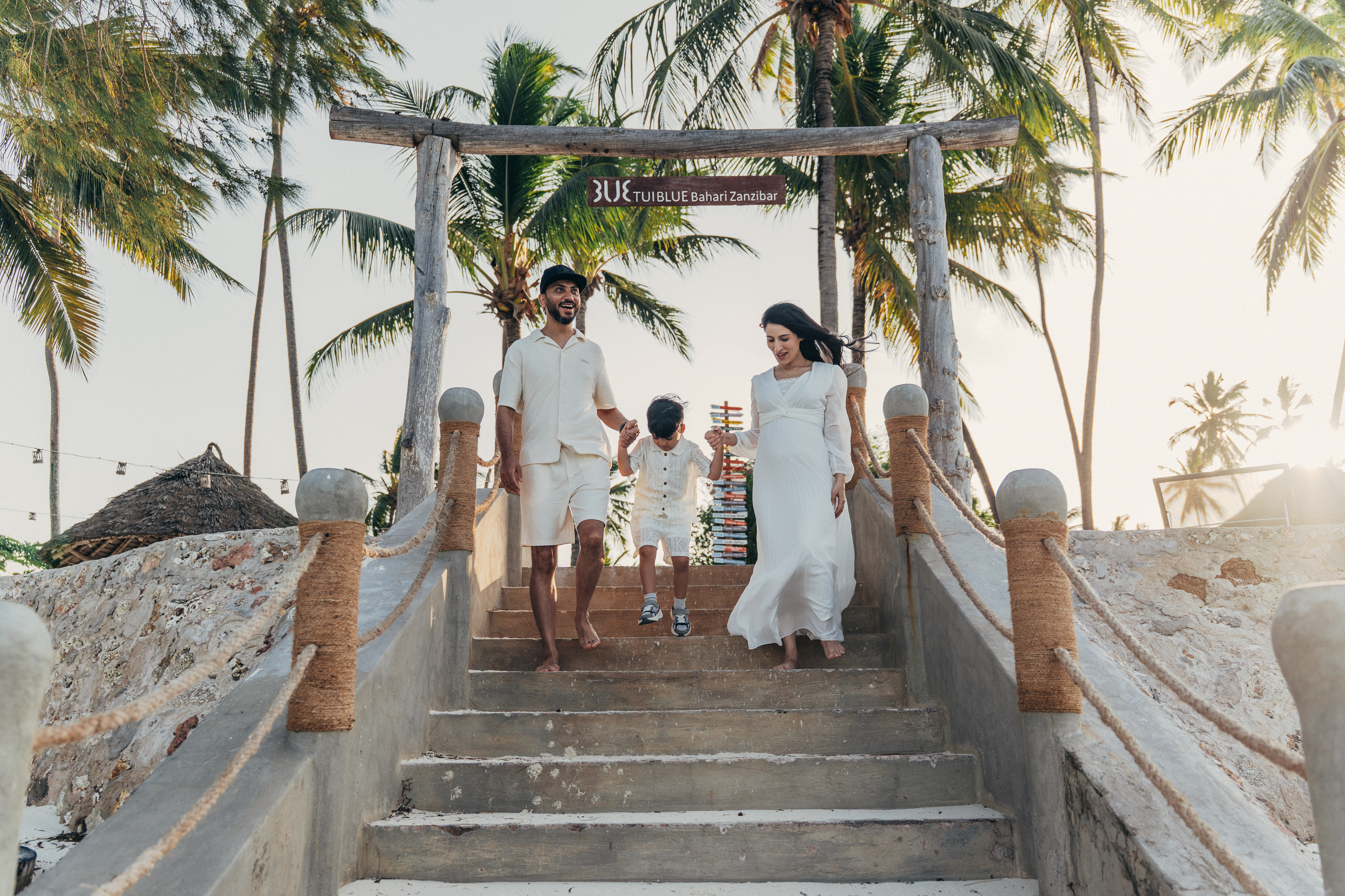 Maternity family photoshoot at TUI BLUE Bahari Zanzibar - family walking down stairs with palm trees