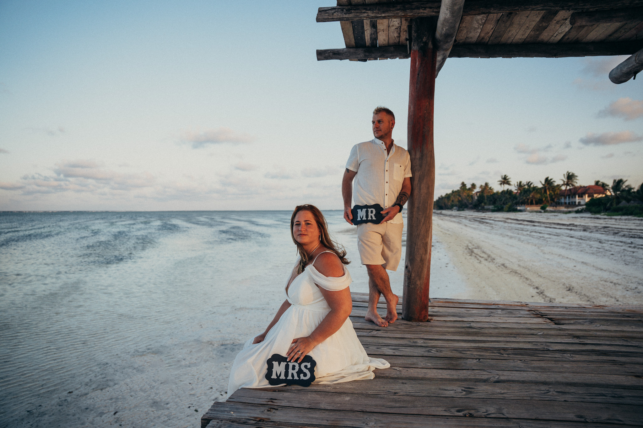 Mr and Mrs couple photoshoot on wooden pier at sunset Zanzibar