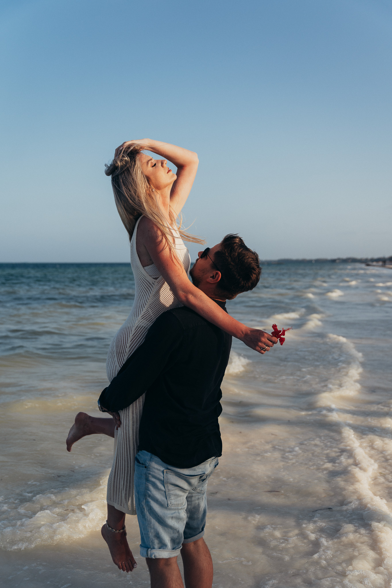 Couple on Zanzibar beach with red flower