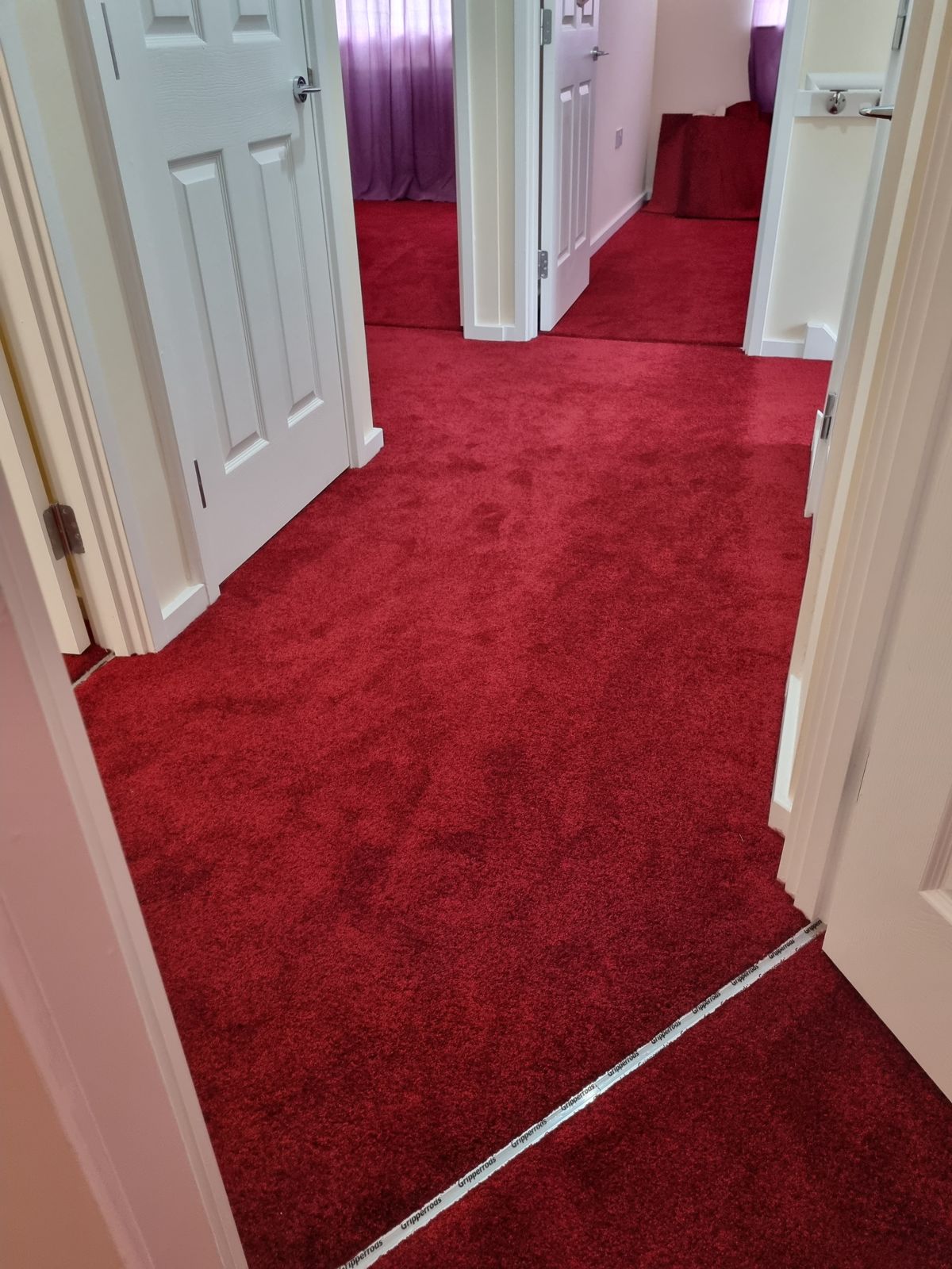 Bright red carpet fitted throughout hallway and rooms