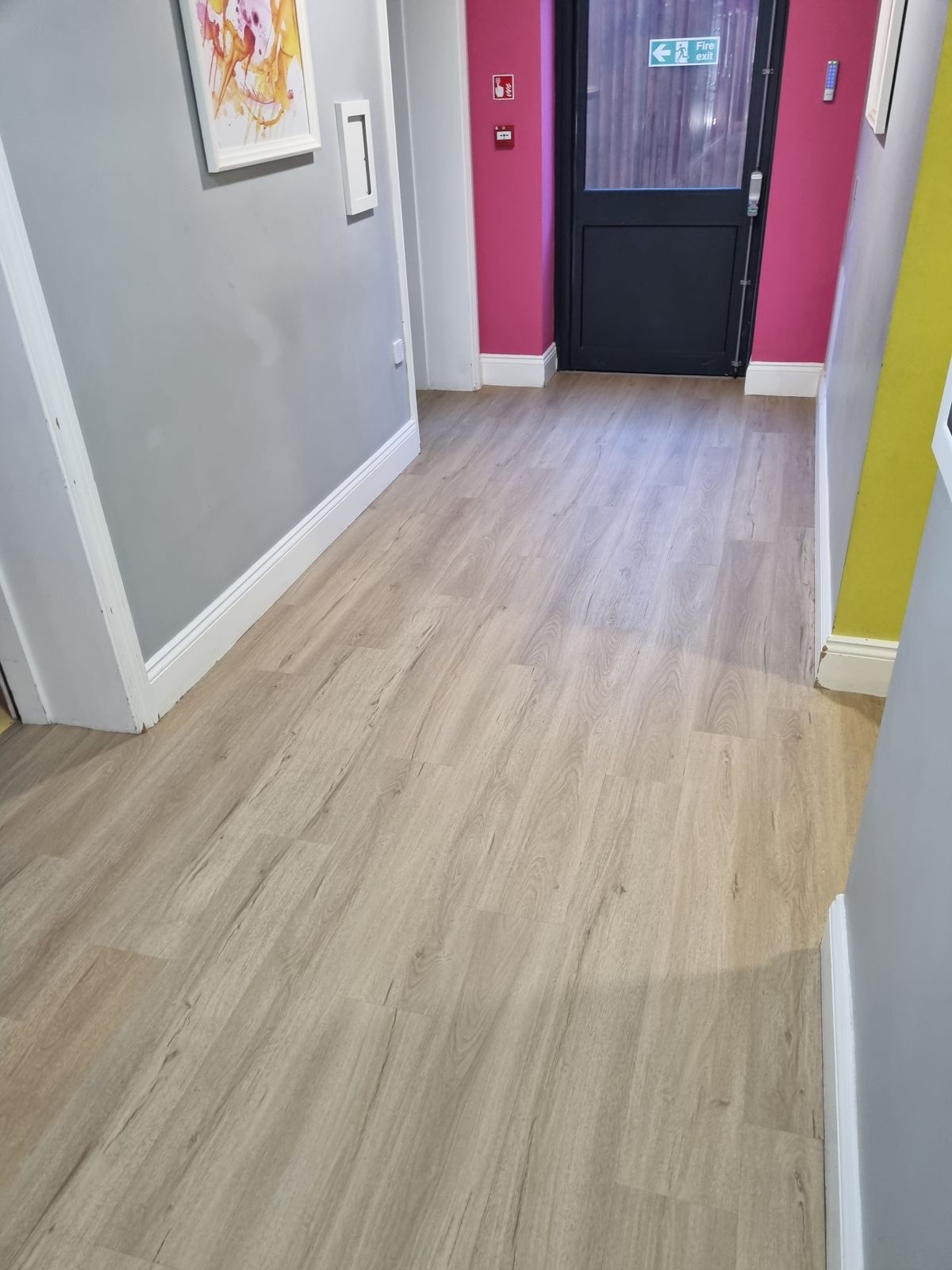 Commercial hallway with LVT wood-effect flooring installed for a clean, durable finish