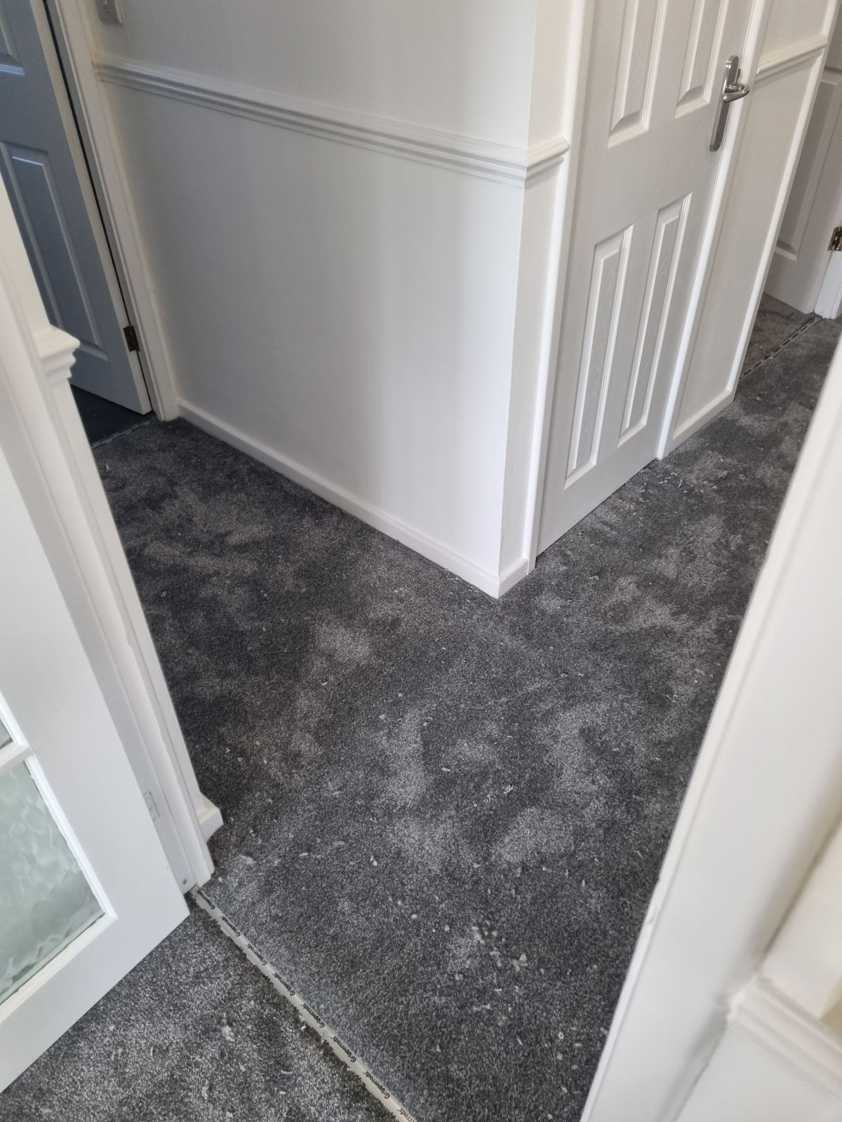 Grey carpet fitted in hallway with multiple rooms