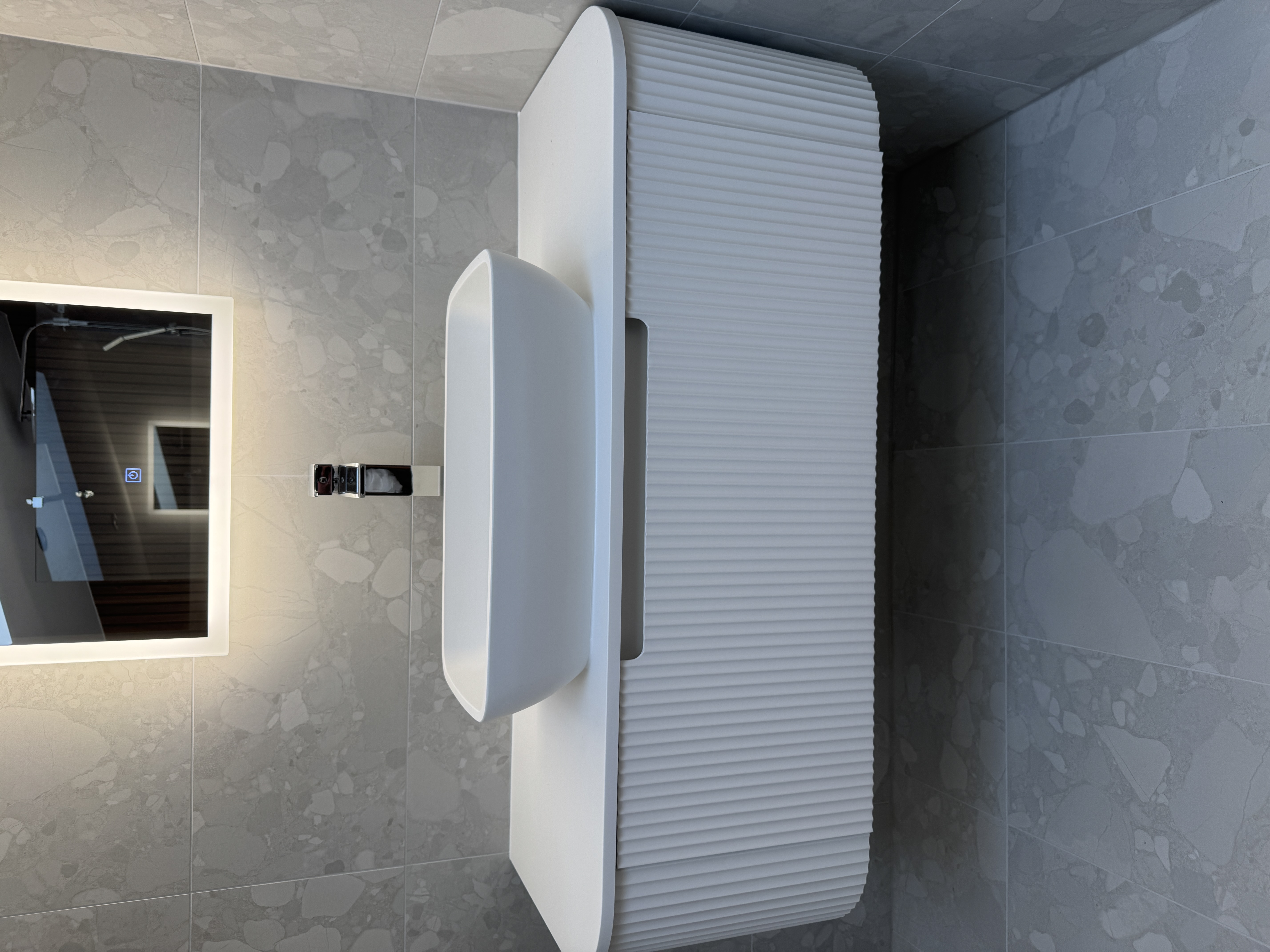 Modern vanity with backlit mirror and ribbed white unit