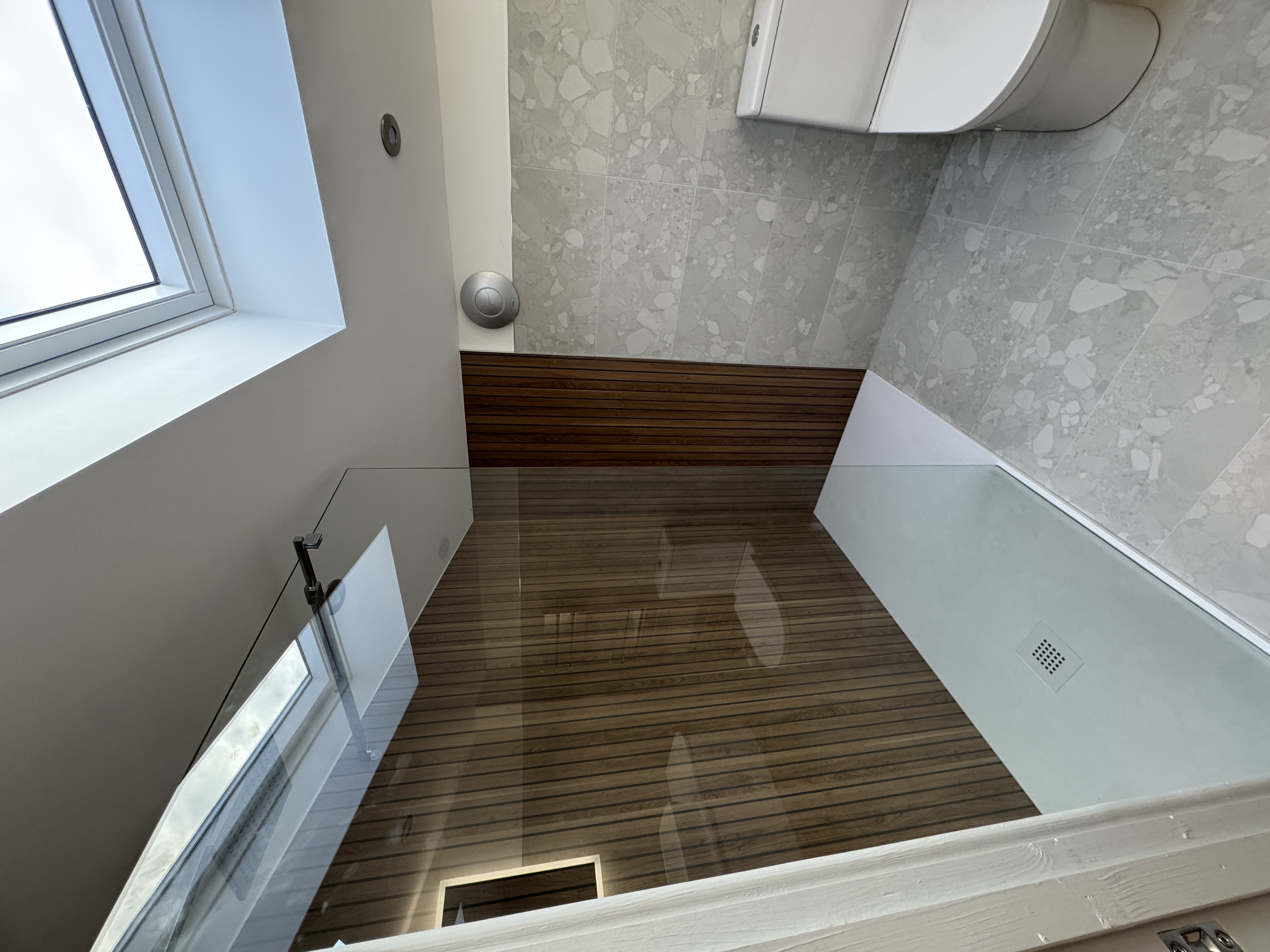 Walk-in shower with wooden slats, skylights and glass enclosure