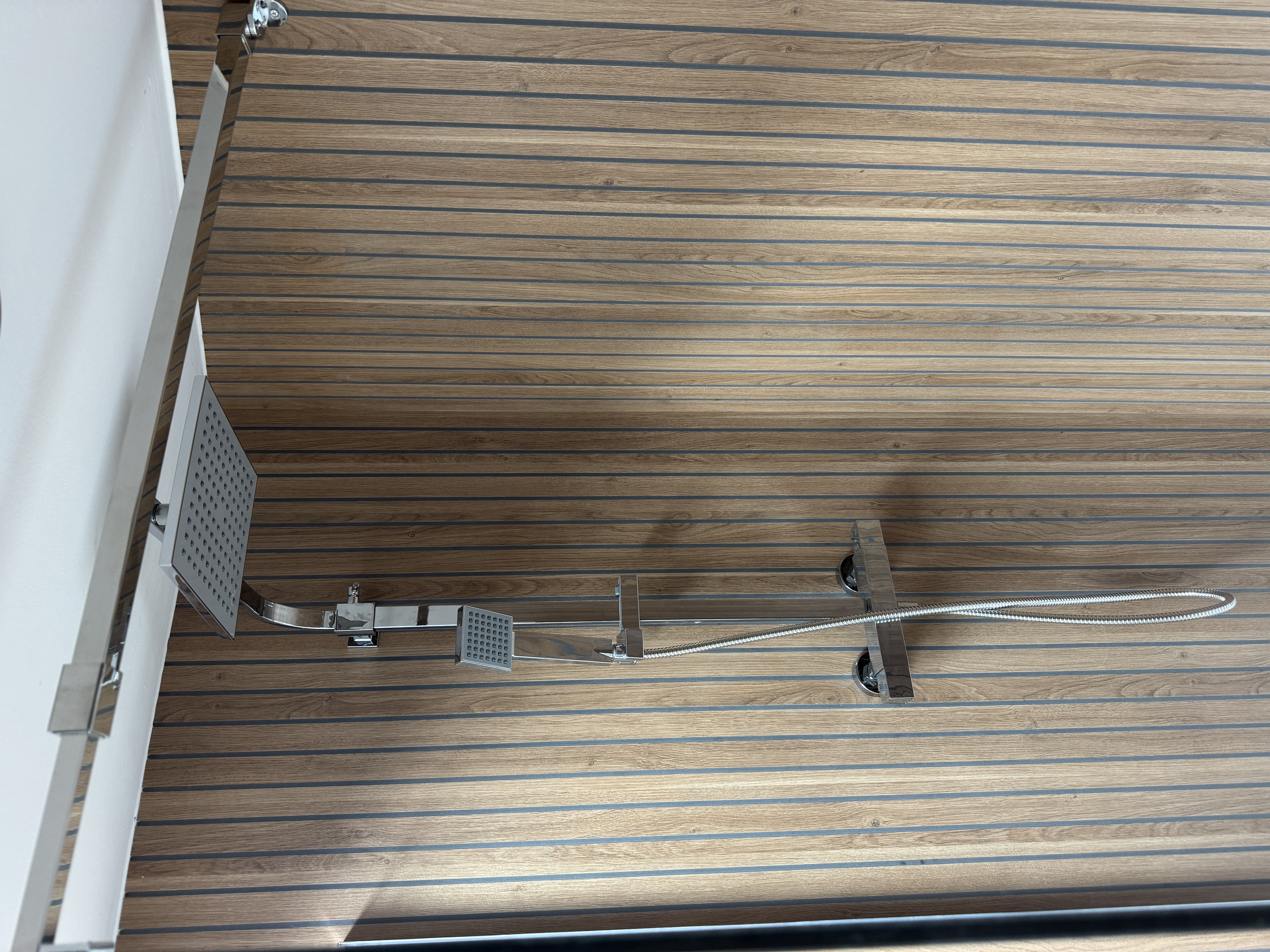 Walk-in shower with wooden slatted walls and rain shower head