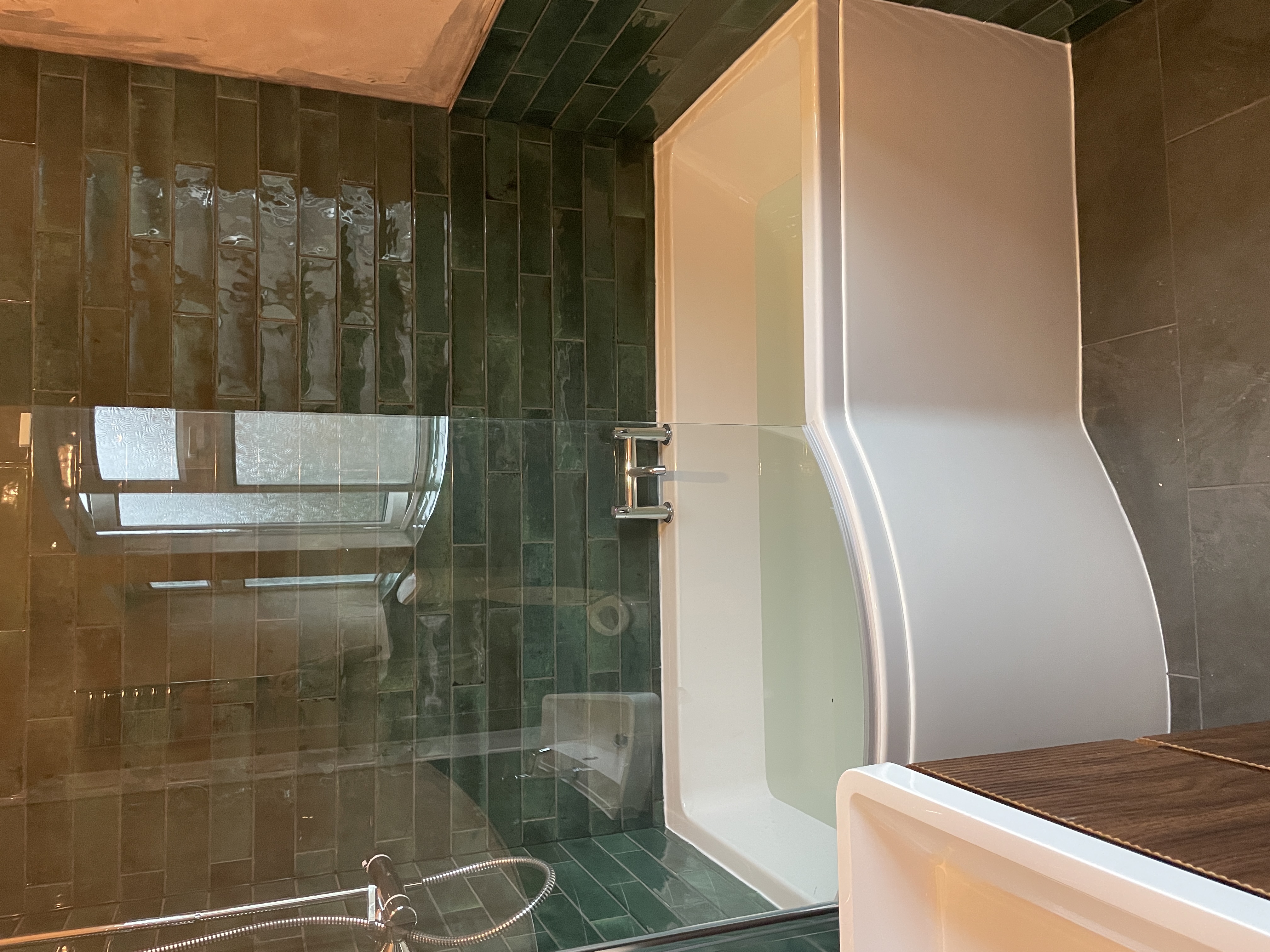 Traditional bathroom with dark green subway tiles and L-shaped bath