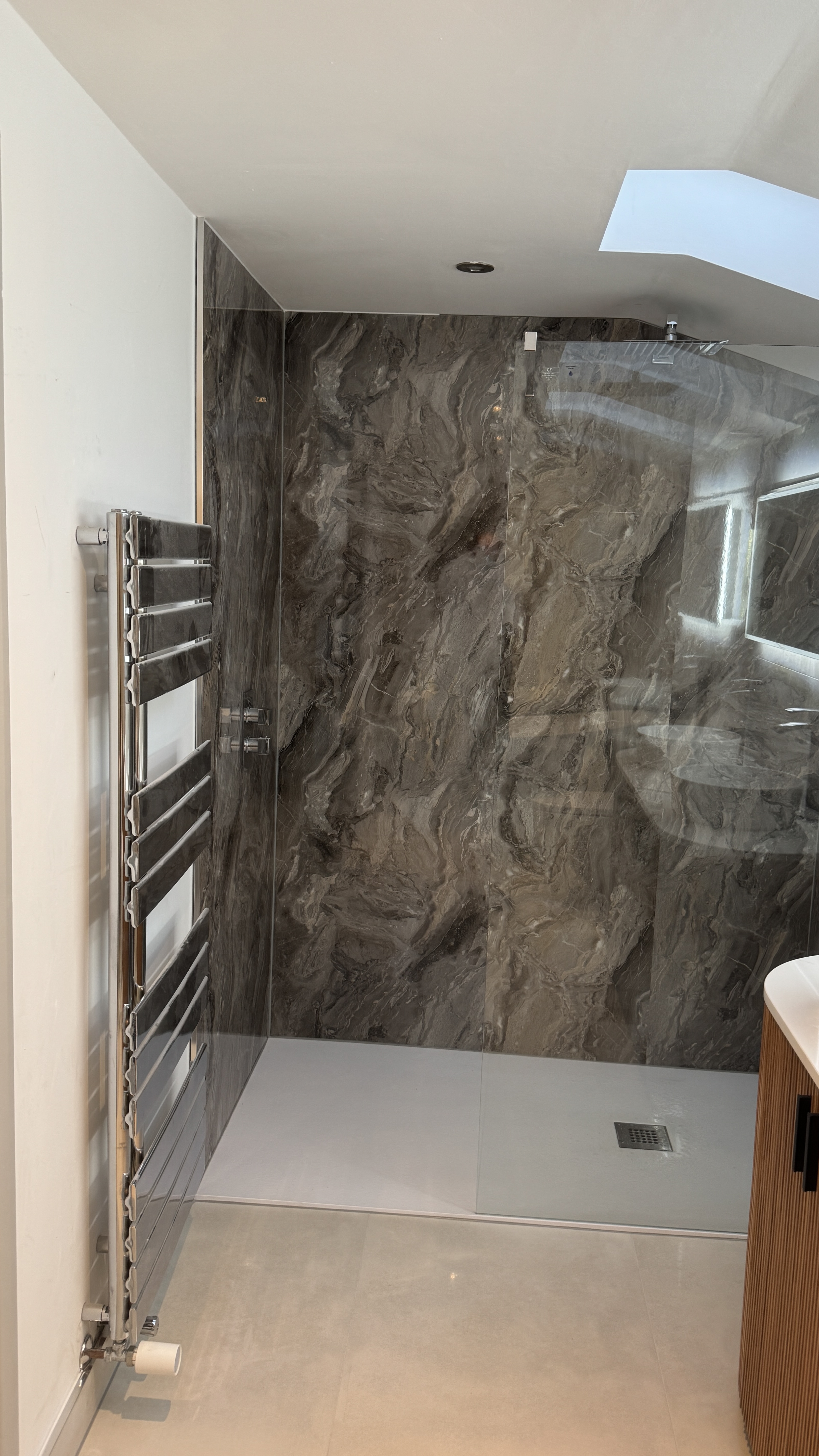 Walk-in shower room with sloped ceiling and skylight