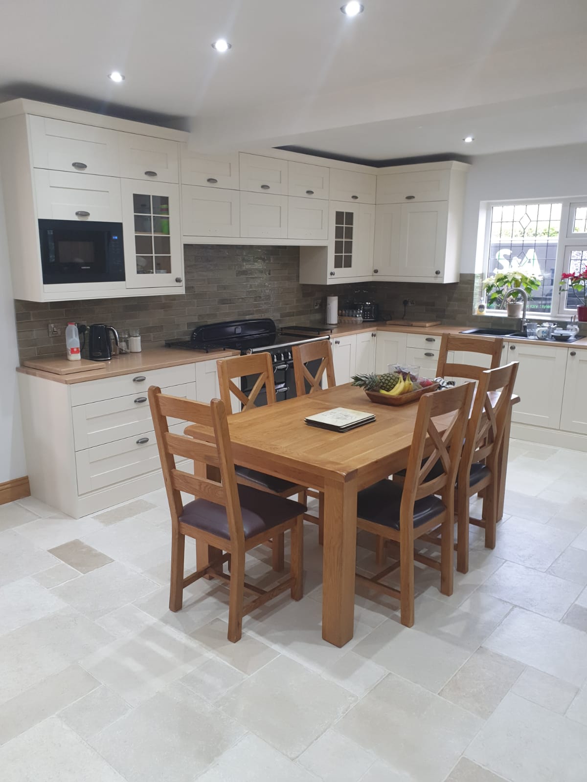 Kitchen with cream cabinets, range cooker and dining area