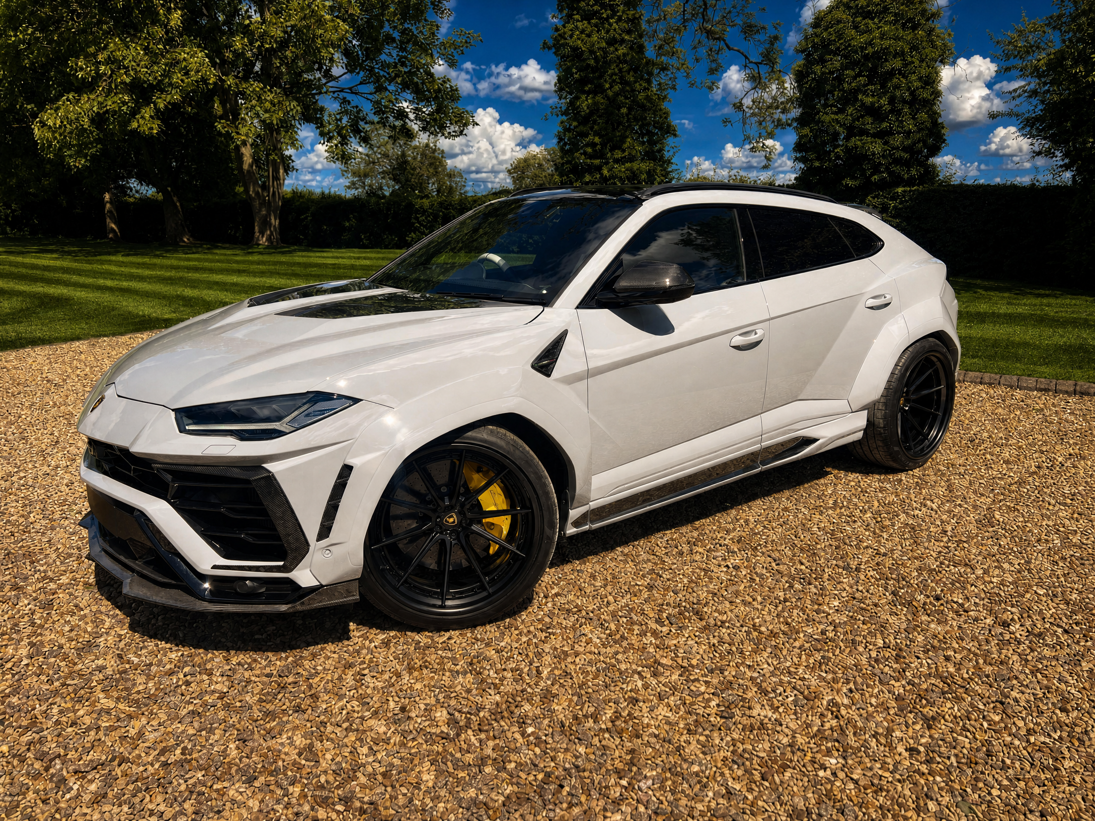 Lamborghini Urus — front-left approach across the estate gravel