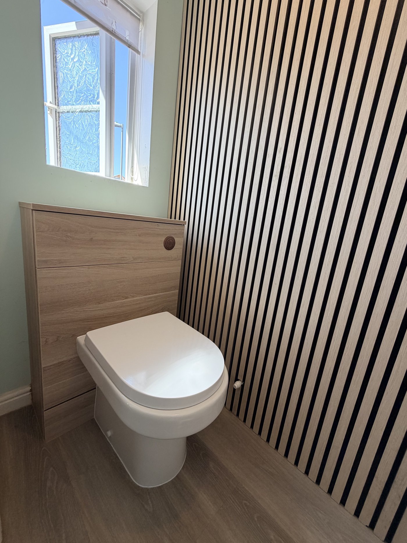 Stylish cloakroom with light oak vanity, vertical wood-slat feature wall, sage green painted wall and brushed copper fittings — Christchurch