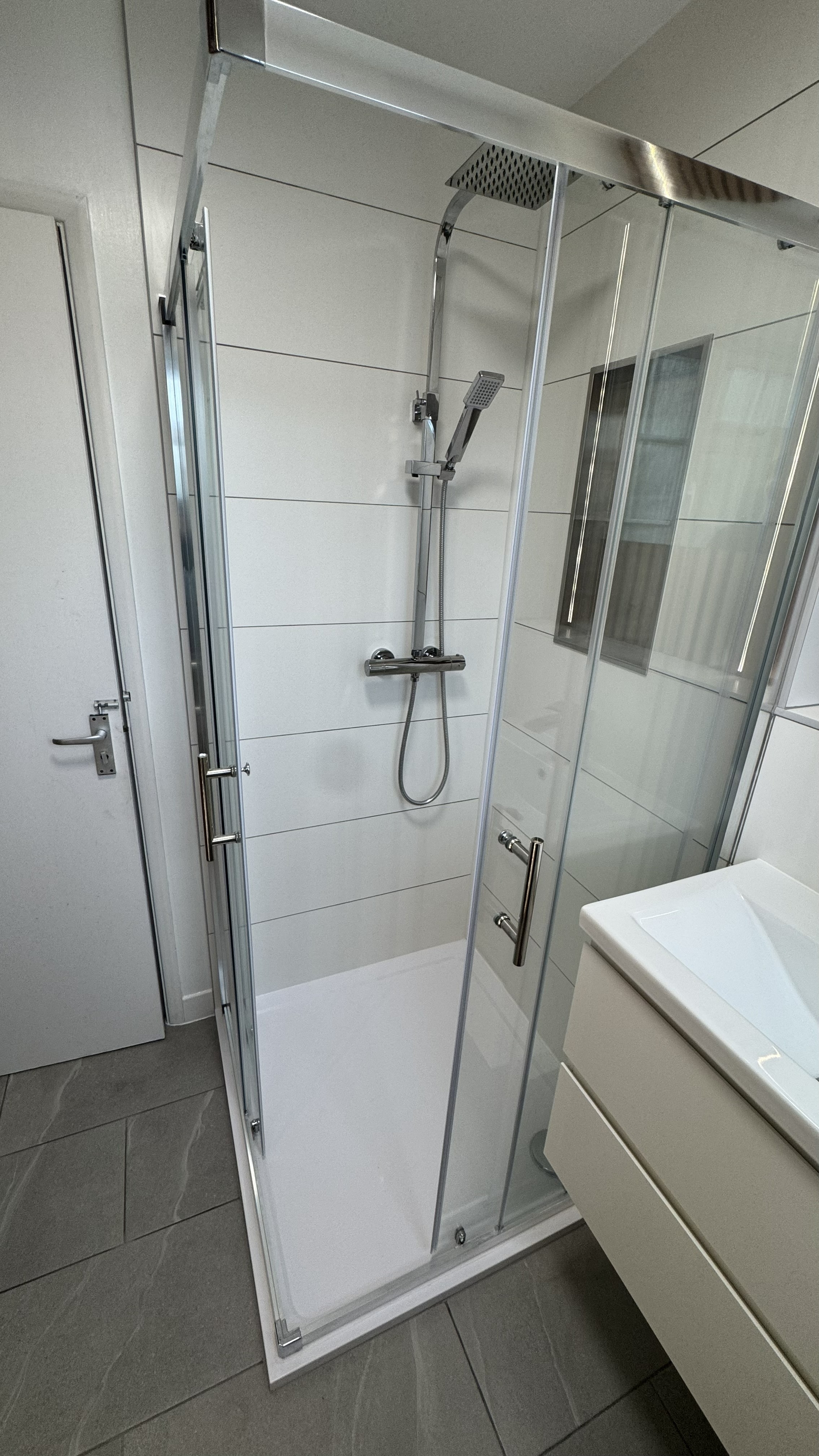 Full-height glass shower enclosure with large-format tiles and vanity unit — Bournemouth