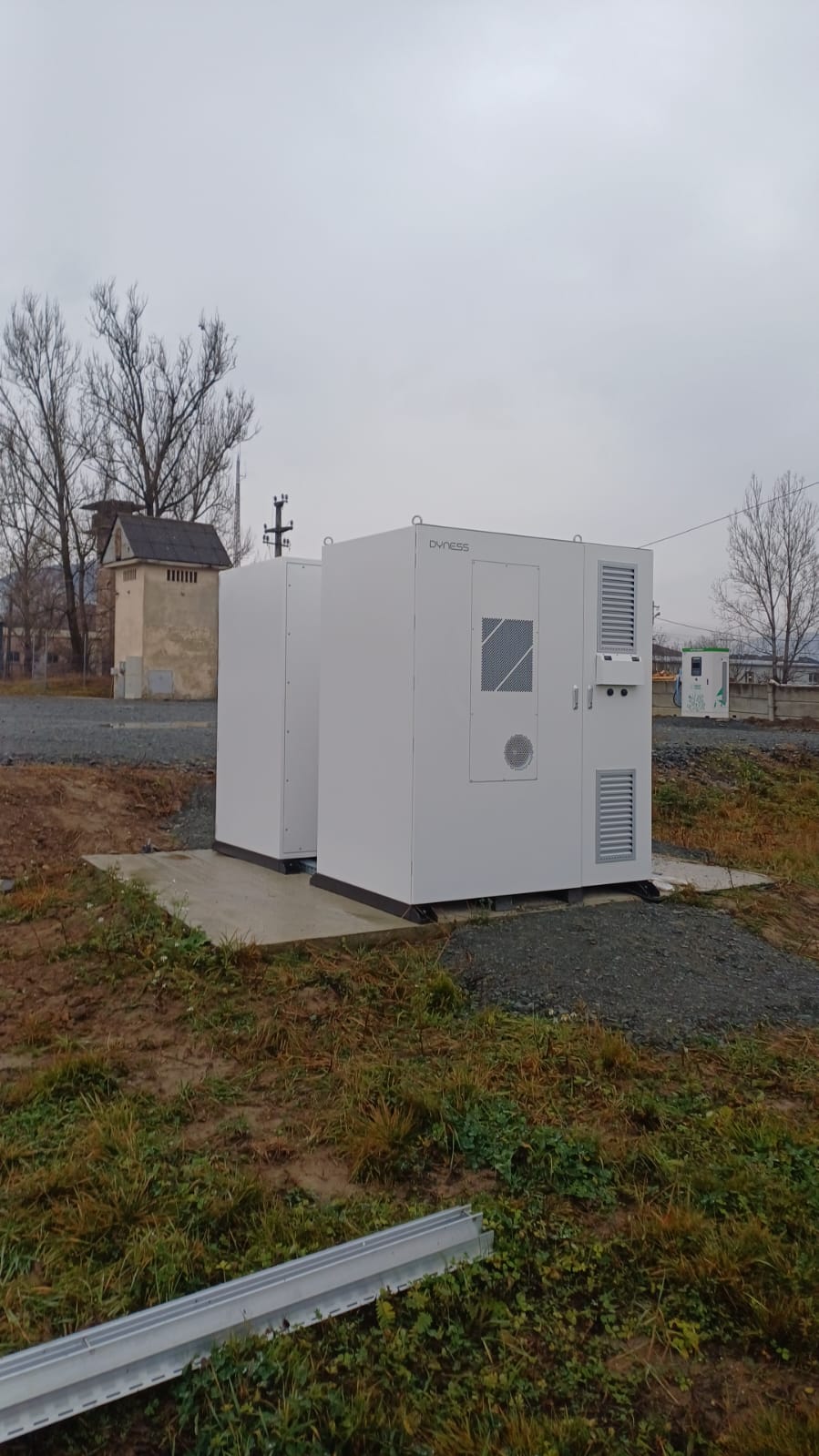 BESS Dyness cu statie incarcare EV in fundal - ecosistem complet FV+stocare+EV