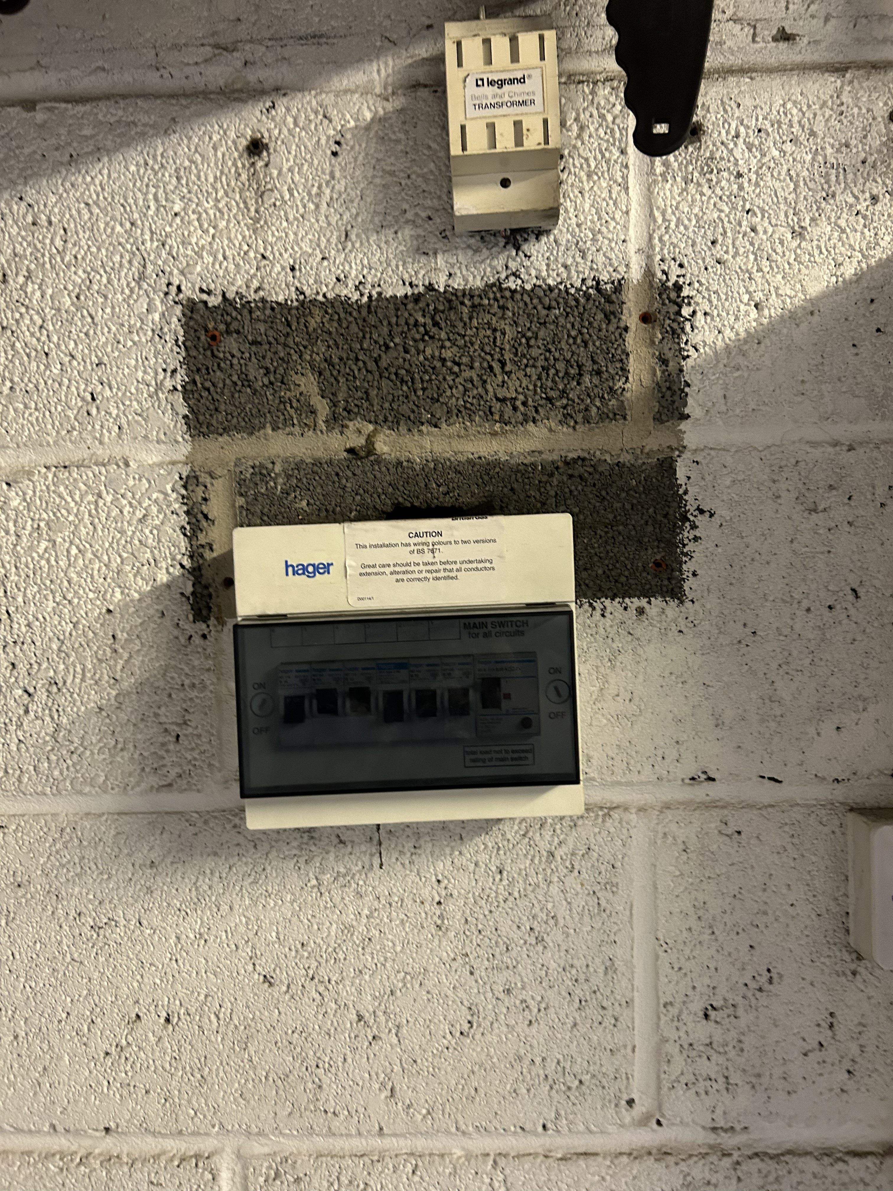 Old Hager consumer unit with dual wiring colours caution notice, older electrical installation due for inspection