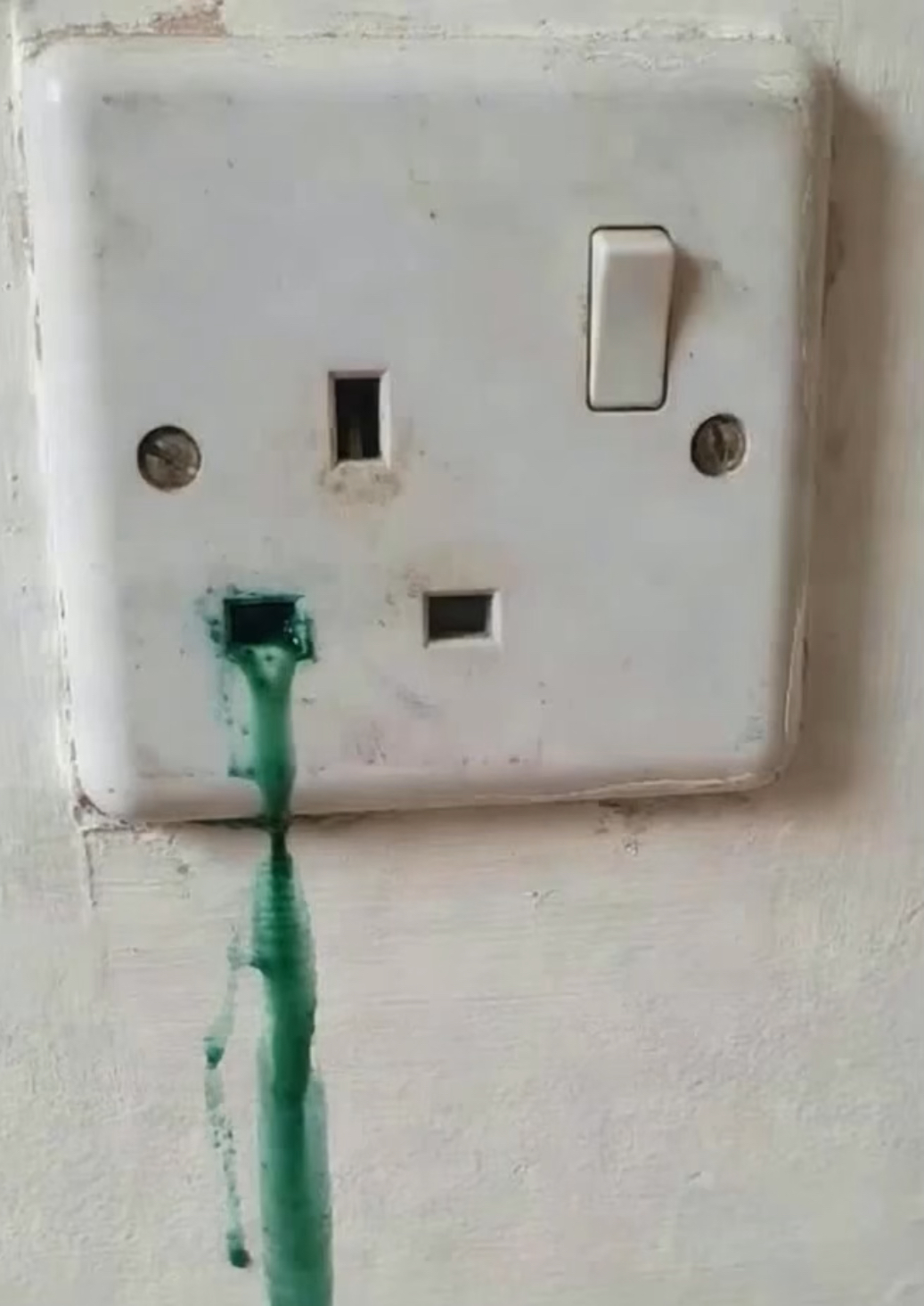 Electrical socket with water ingress causing green corrosion, dangerous fault found during EICR inspection