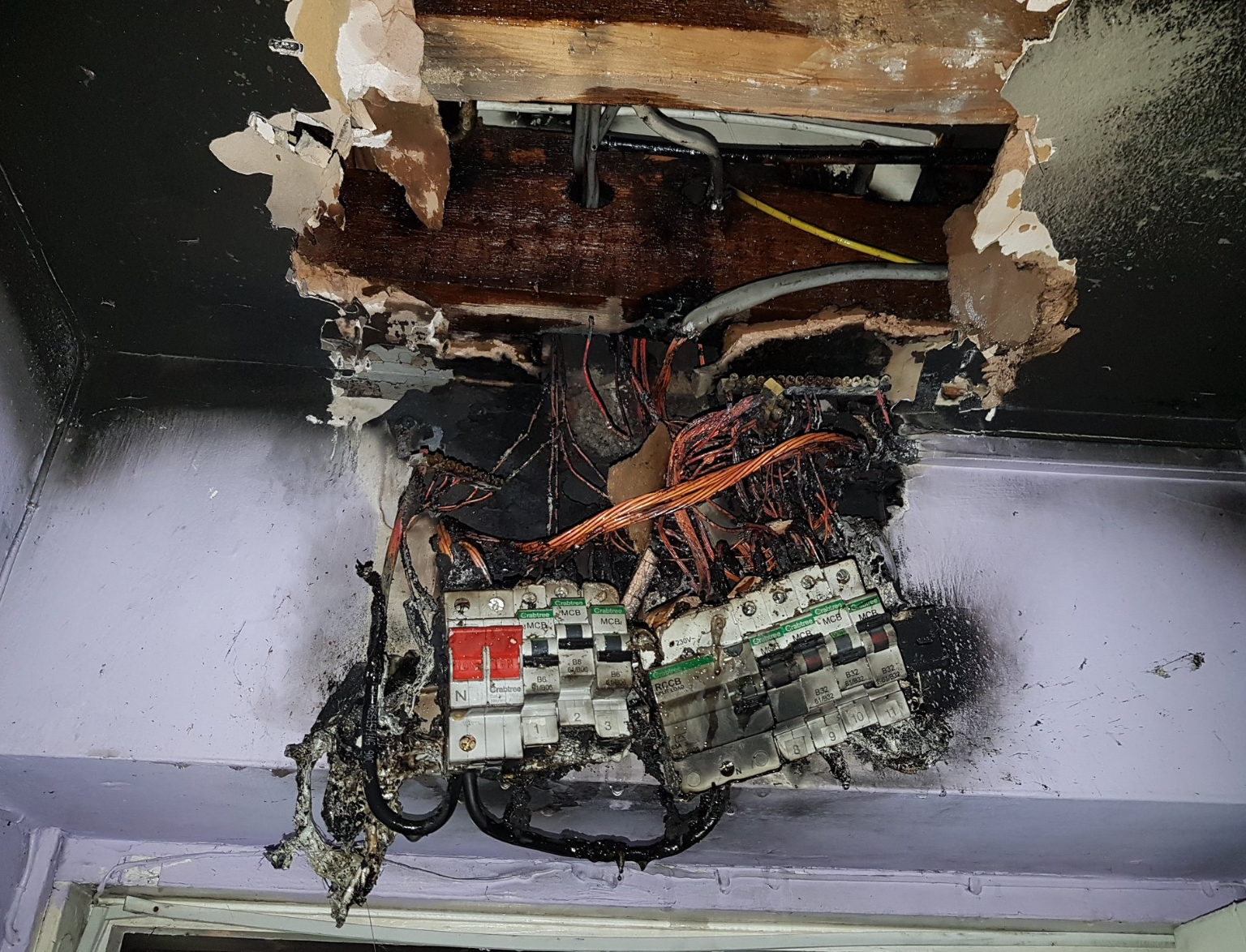 Burned-out plastic fuse board — fire damage caused by arcing inside the enclosure